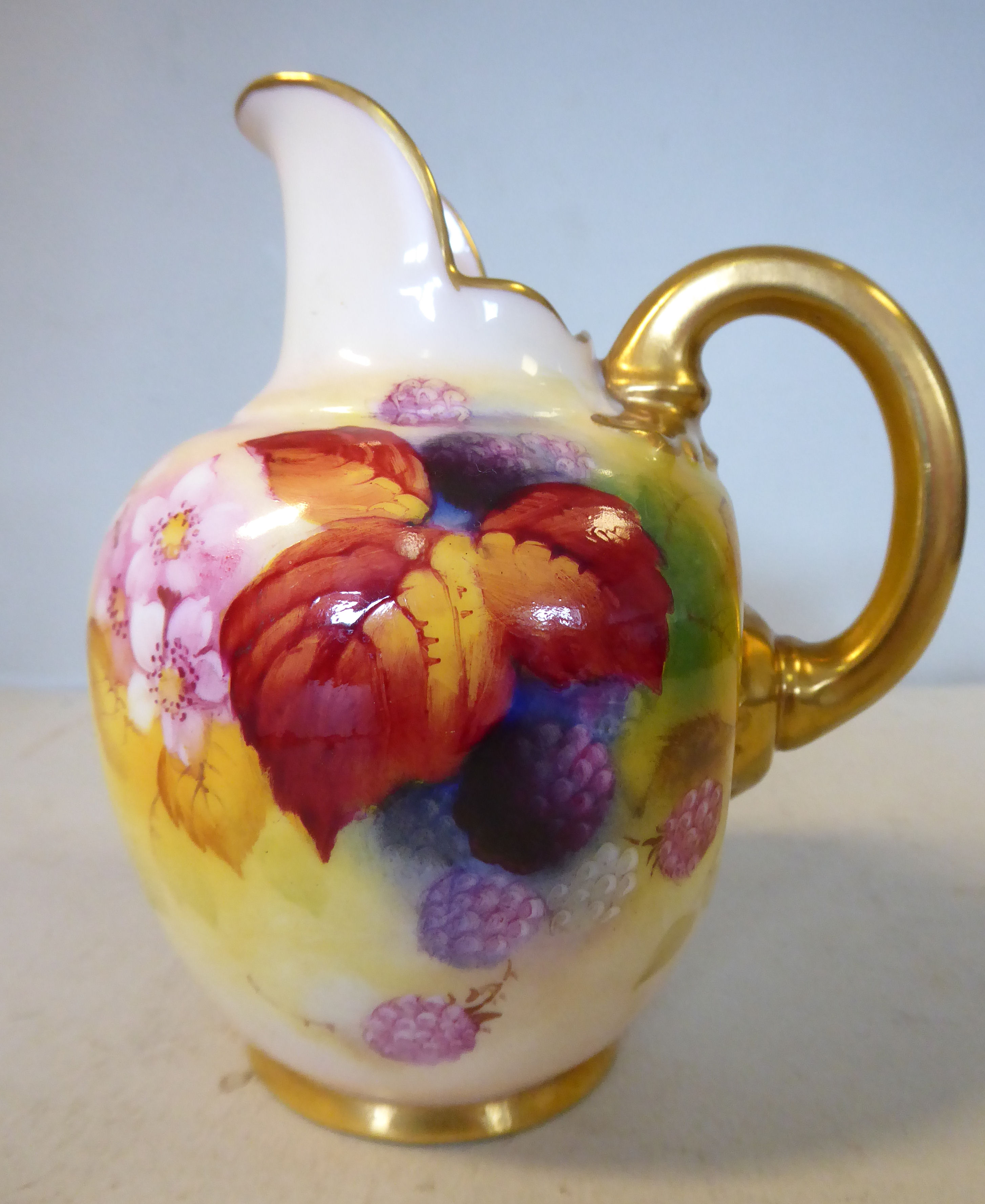 A Royal Worcester china ovoid shaped cream jug, having an upstand pouring lip and a loop handle,