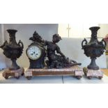 A late 19thC Continental cast and painted spelter and mottled iron red marble clock garniture,