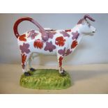 A 19thC Staffordshire mauve and iron red lustre glazed pottery cow creamer,