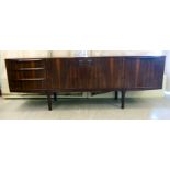 A 1970s AH McIntosh & Co rosewood veneered sideboard, comprising a pair of central doors,