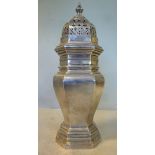 A silver caster of elongated octagonal vase design with a decoratively pierced,