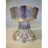 An Edwardian silver cup, embossed, cast and chased with uniform ornament, the wide,