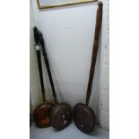 Three similar late Victorian brass and copper warming pans,