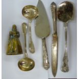 A silver handled Kings pattern slice; a silver plated bread knife; and a cast brass table bell,