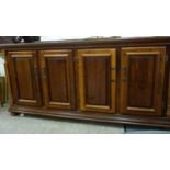 A 20thC 'bespoke' walnut sideboard, comprising four in-line panelled doors,