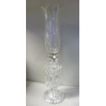 A clear crystal lustre candlestick with a vase shaped socket and prism pendants, on a circular base,