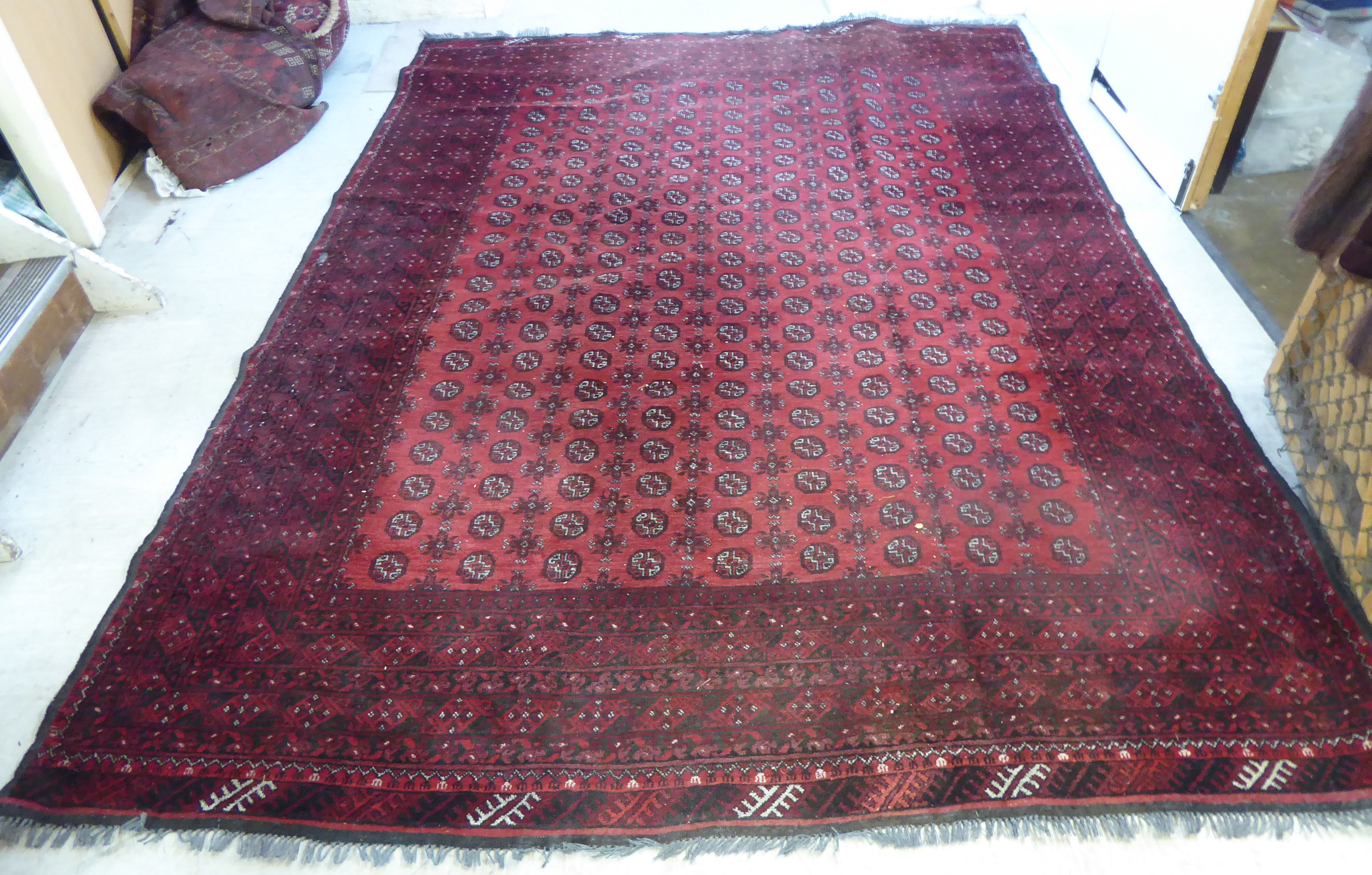 A Bokhara carpet with repeating elephant foot motifs on a red ground 137'' x 101'' - Image 2 of 12
