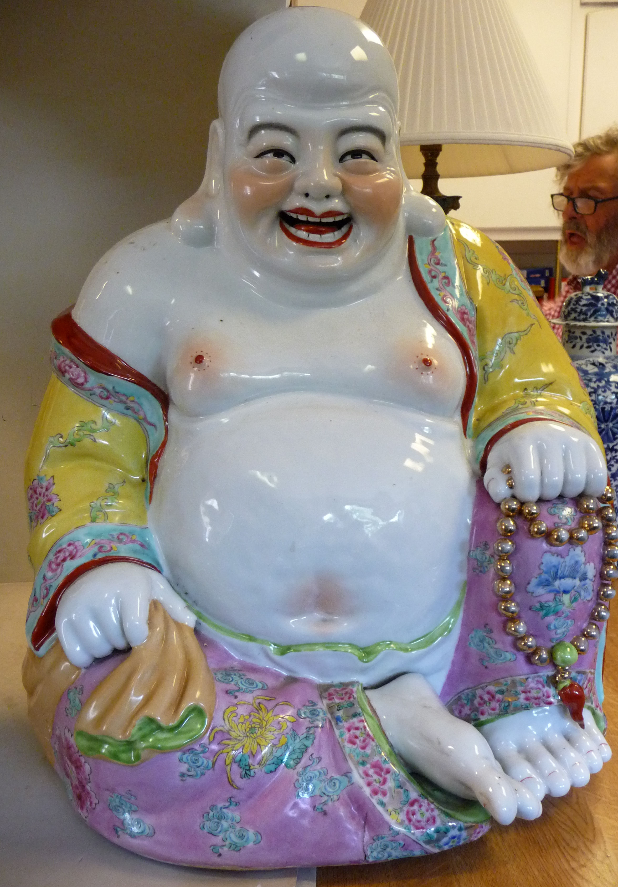 A 20thC porcelain figure, a seated Buddha,