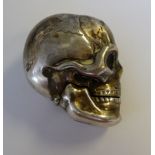An early 20thC Continental silver coloured metal novelty vesta case, fashioned as a human skull,