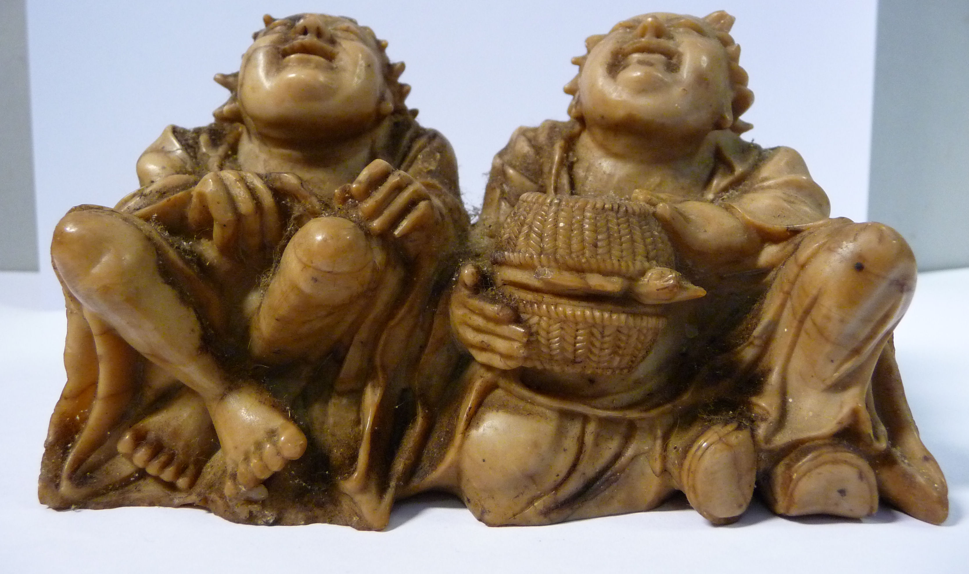 An 18th/19thC Chinese carved light brown soapstone group, two seated corpulent fishermen,