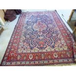 A Persian carpet with a central eight point star medallion, in a foliate scrolled surround,