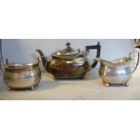 A three piece silver tea set of panelled, oval ogee form comprising a teapot with a gadrooned rim,