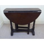 A late 18thC oak occasional table, the oval top with fall flaps,