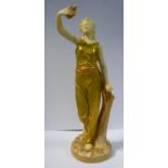 A Royal Worcester gilded and painted satin glazed china figure, a woman holding a dove,