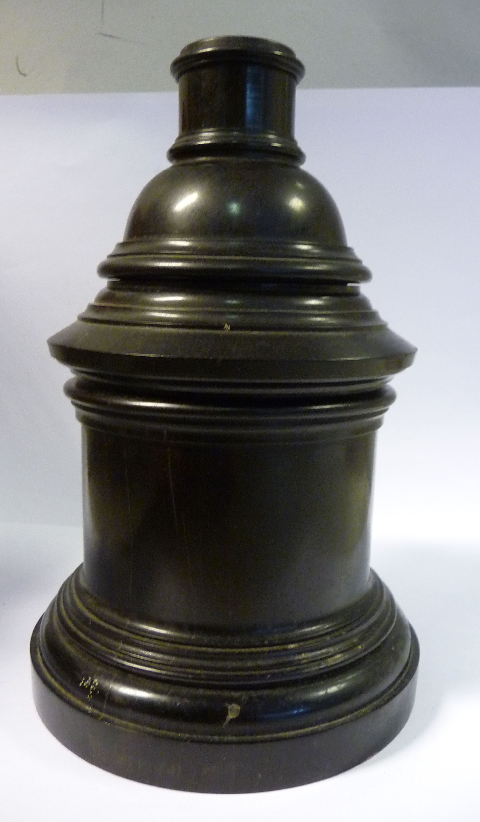 A late 19th/early 20thC black composition three part smoker's companion, comprising a drum base,