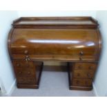 A late Victorian mahogany cylinder front desk,