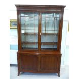 A Regency mahogany cabinet bookcase, the superstructure with a level cornice,