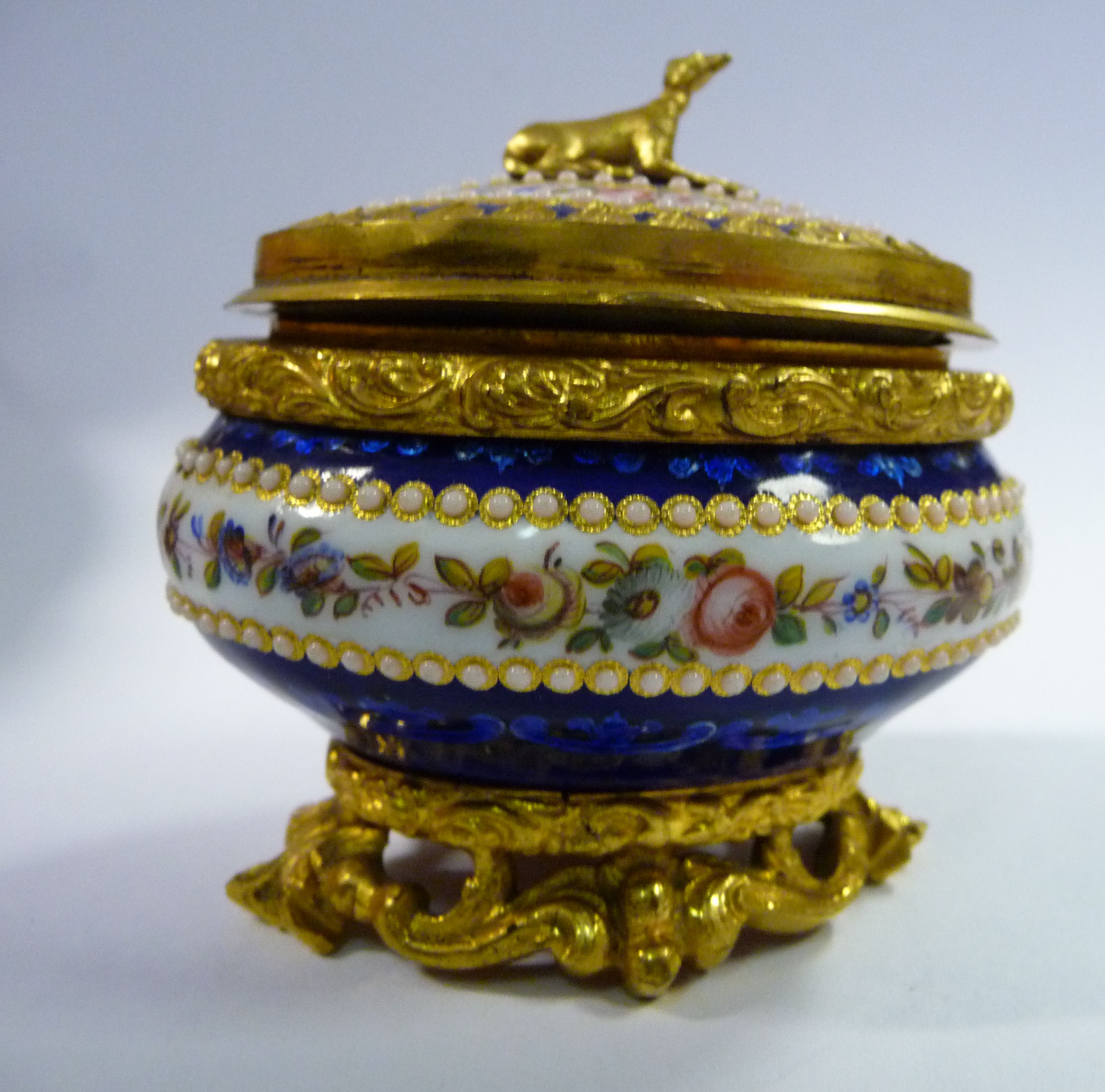 An early 20thC Continental cast gilt metal, midnight blue enamel and floral decorated oval ring box,