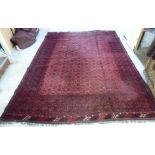 A Bokhara carpet with repeating elephant foot motifs on a red ground 137'' x 101''