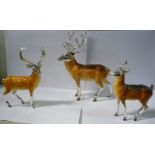 A 'family' of three silver coloured metal and finely painted enamel models, standing deer, viz.