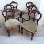 A set of six mid Victorian mahogany framed balloon back dining chairs, each with a carved,