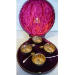 A set of four late Victorian silver circular salt cellars with embossed swept,