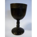 A mid 19thC turned ebony cup, the bowl with fine lined ornament to the rim,