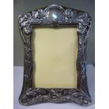 An Edwardian silver photograph frame of incurved design, on an oak back and easel stand,