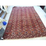 A Bokhara rug with repeating elephant foot motifs on a red ground 131'' x 89''