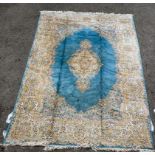 A Kirman carpet with a central medallion bordered by stylised foliage on a pale blue ground 122''