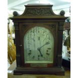 An Edwardian carved mahogany cased bracket clock with a platform top, between scrolled flanks,