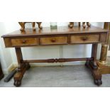 An early/mid 19thC mahogany writing table with three in-line drawers, raised on plank ends,