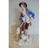 A 20thC German porcelain figure, a standing man with two sheep at his feet, on a floral encrusted,