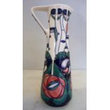 A modern Moorcroft pottery jug of slender, tapered form with an angular strap handle,