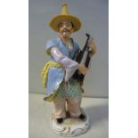 A 20thC German porcelain figure, a standing Chinaman, playing a stringed instrument,