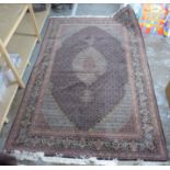 A Persian carpet with a central serpentine outlined medallion,
