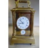 An early/mid 20thC lacquered brass cased carriage clock with bevelled glass panels,