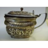 A George III silver mustard pot of oval ogee form with an angular loop handle, hinged lid,