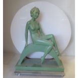 A 1930s Art Deco green painted plaster table lamp, fashioned as a seated nude on a crescent seat,