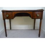 A George III ebony inlaid mahogany, concave front kneehole writing table with a low,