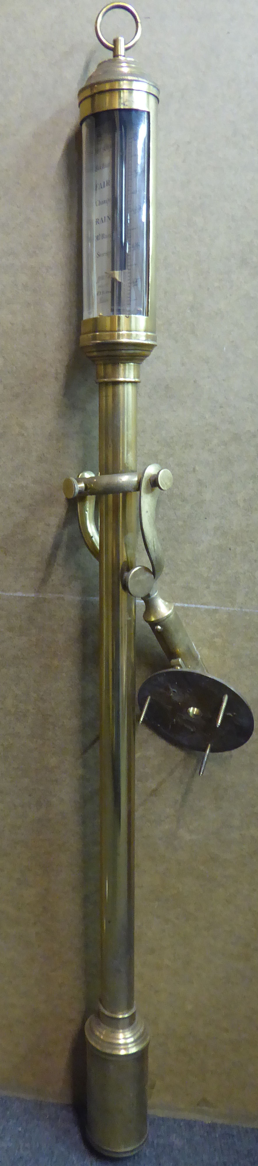 An early 20thC lacquered brass cased marine barometer with engraved, silvered steel register plates,