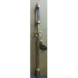 An early 20thC lacquered brass cased marine barometer with engraved, silvered steel register plates,