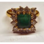 An 18ct gold ring, set with a central emerald,