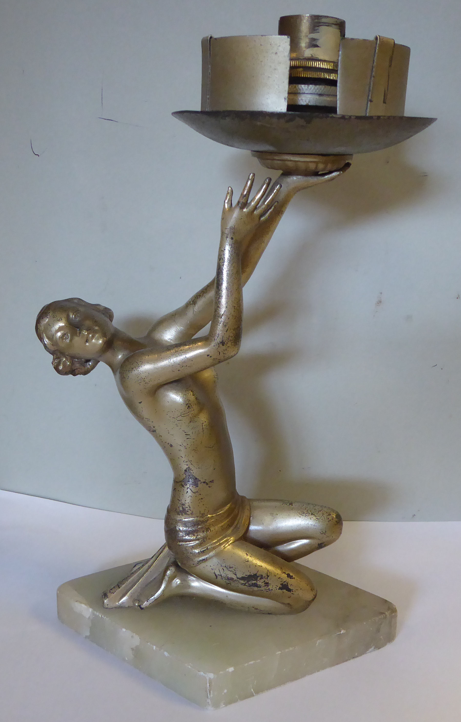 A 1930s Art Deco silver patinated spelter table lamp, a kneeling dancer holding a light fitting,