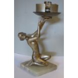 A 1930s Art Deco silver patinated spelter table lamp, a kneeling dancer holding a light fitting,