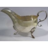An Edwardian Irish silver sauce boat with an acanthus topped, double C-scrolled handle,