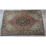 A Persian silk rug with a central serpentine outlined medallion,