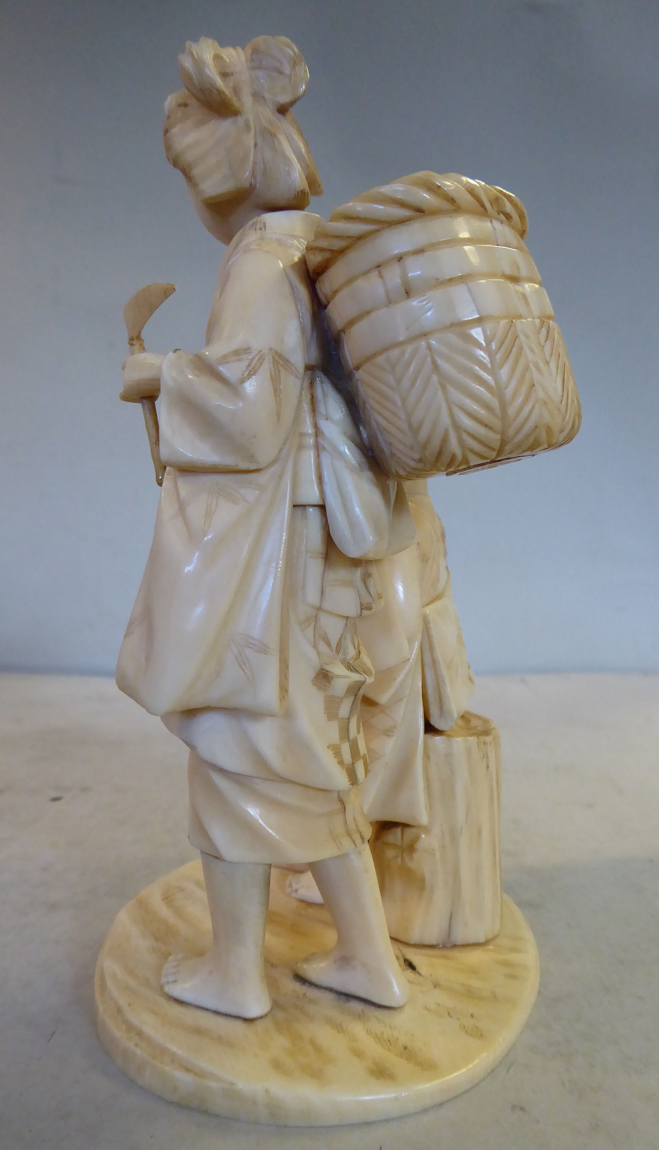 An early 20thC Japanese carved ivory artisan group, two women, one standing, the other seated, - Image 2 of 5