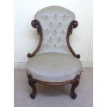 A late Victorian carved walnut showwood framed boudoir chair with a high, waisted,