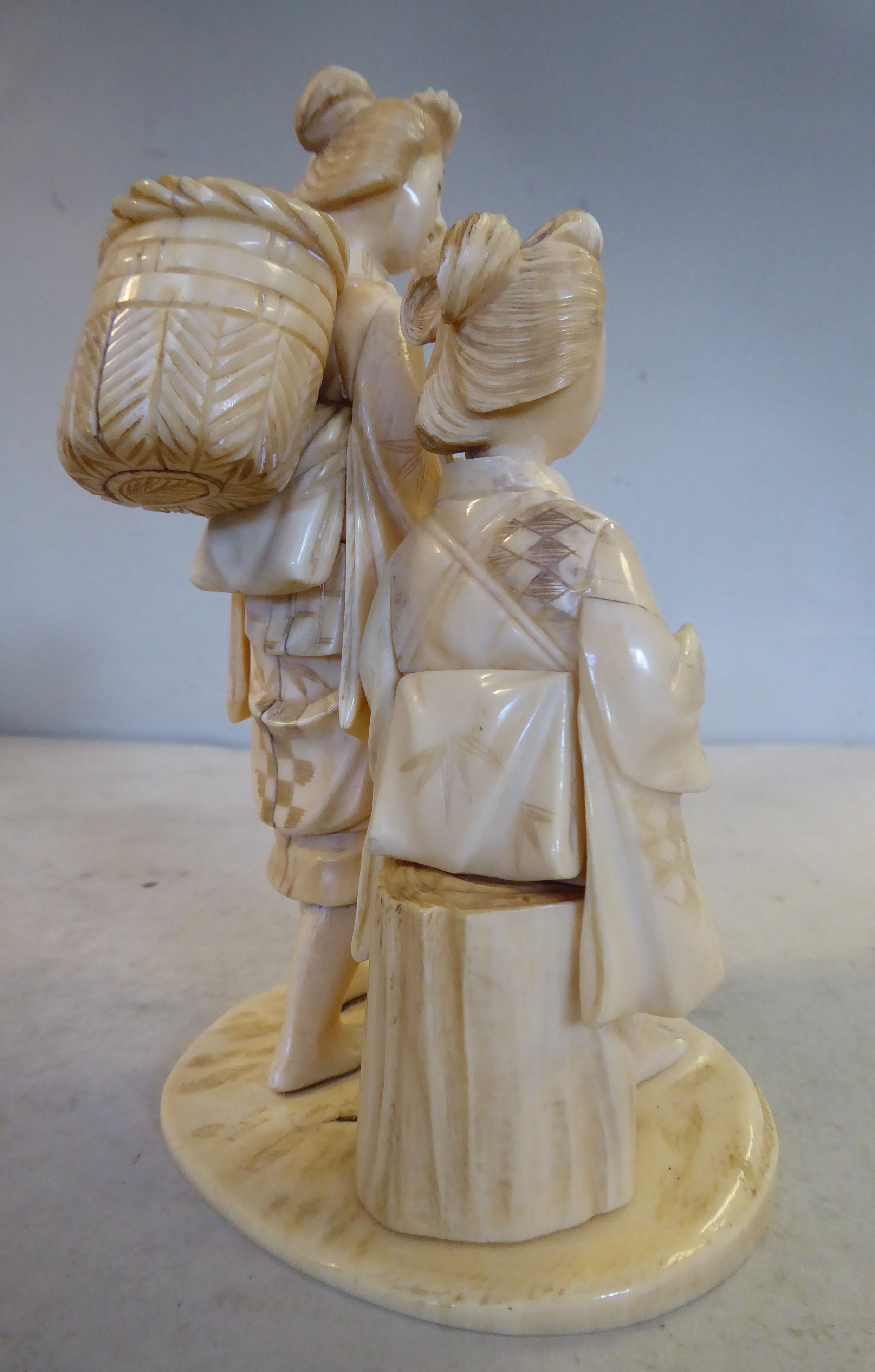 An early 20thC Japanese carved ivory artisan group, two women, one standing, the other seated, - Image 3 of 5